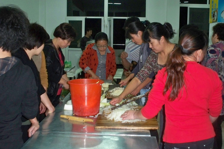 学员和社区工作人员一起准备包子馅